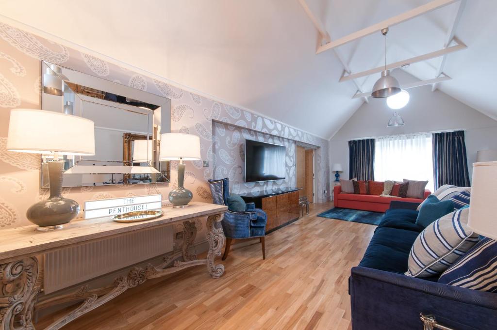 a living room with a blue couch and a mirror at Suites at number Ten in Broadstairs