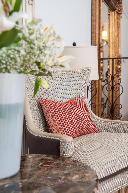 a red pillow sitting on a chair with a table at Suites at number Ten in Broadstairs