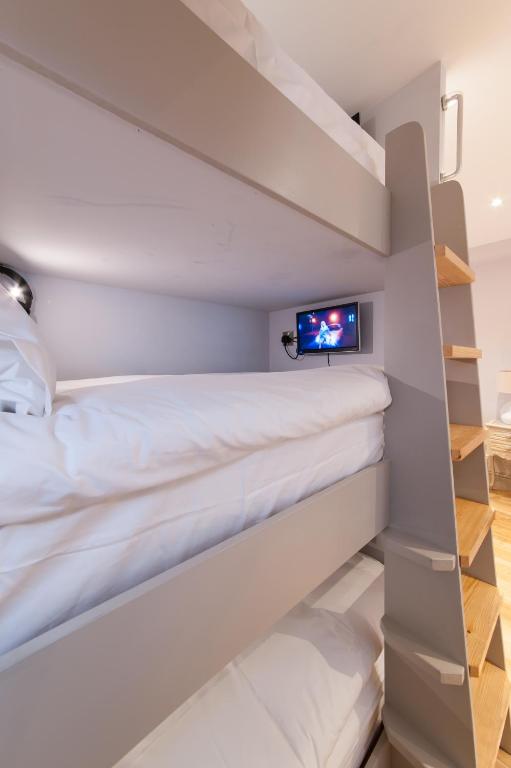 a room with a bed and a tv on a wall at Suites at number Ten in Broadstairs