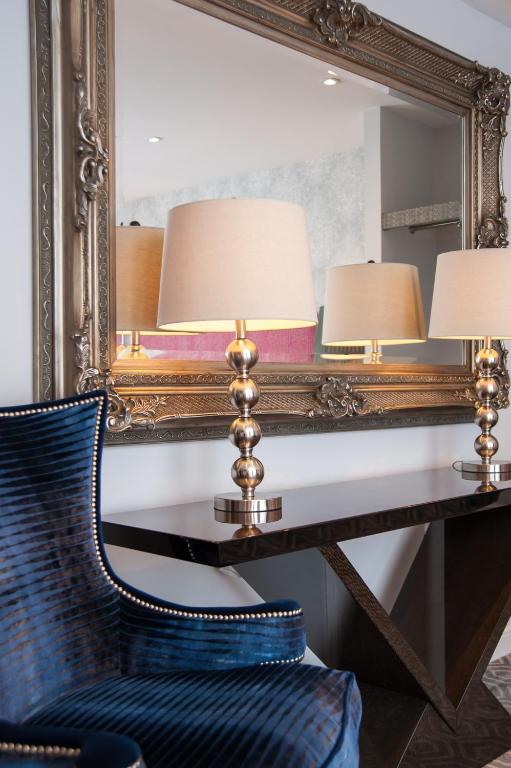 a mirror with two lamps and a chair in front of a desk at Suites at number Ten in Broadstairs