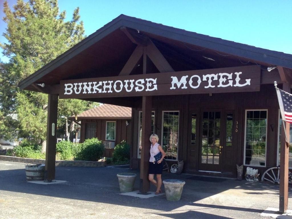 a woman standing in front of a store with a sign at Bunkhouse motel in Guernsey