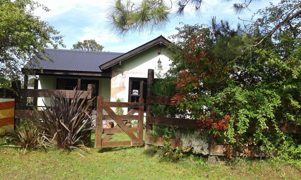una pequeña casa blanca con una valla y una puerta en Casa Picoco en San Bernardo