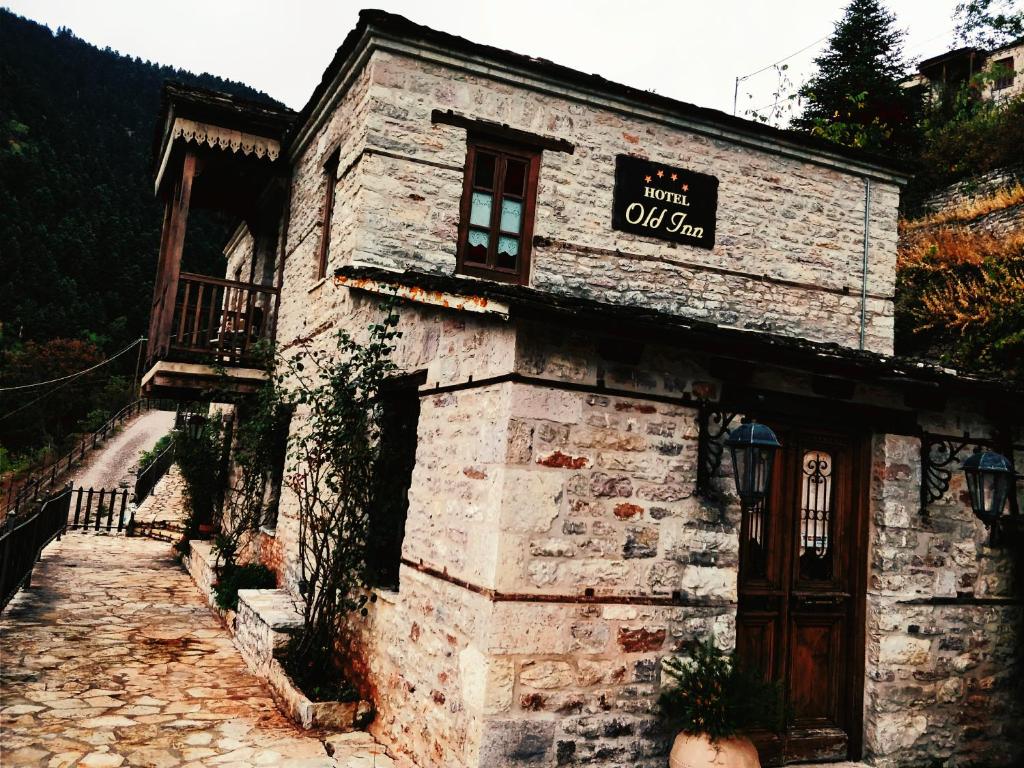 an old stone building with a sign on it at Old Inn in Karpenisi