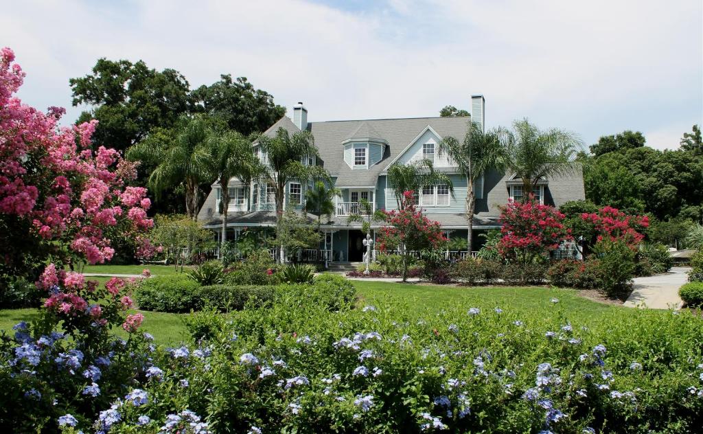 ein großes Haus mit Blumen im Hof in der Unterkunft Heron Cay Lakeview Bed & Breakfast in Mount Dora