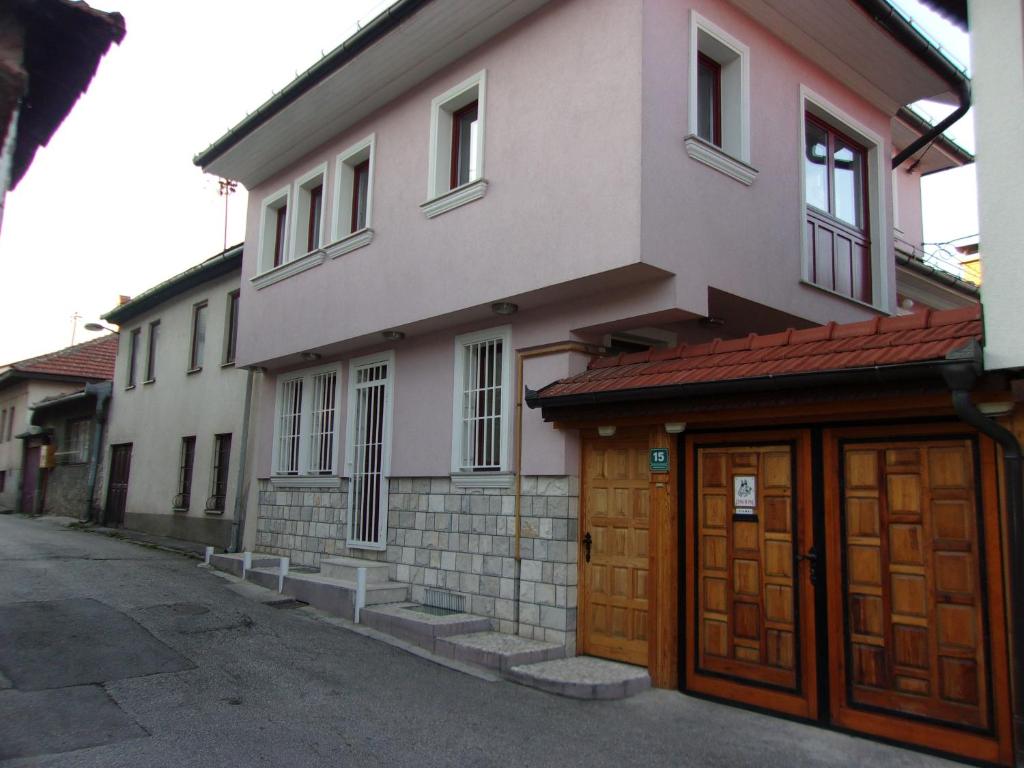une maison avec deux portes en bois dans une rue dans l'établissement Tower House, à Sarajevo
