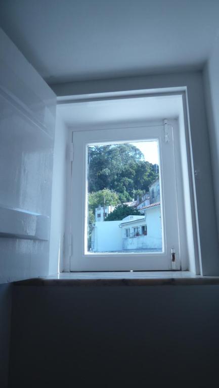 a window in a room with a view of a house at ribeira dos marinheiros amarelo in Sintra