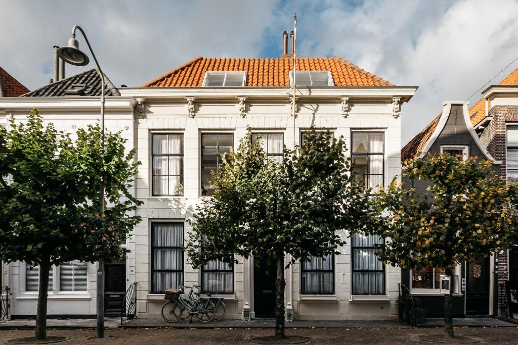 um edifício branco com um telhado laranja em De Verwennerie em Zierikzee