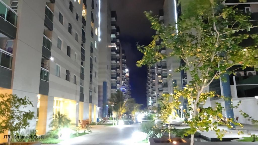 una calle de la ciudad por la noche con edificios altos en Apart no Cond JTR - Maceió, en Maceió