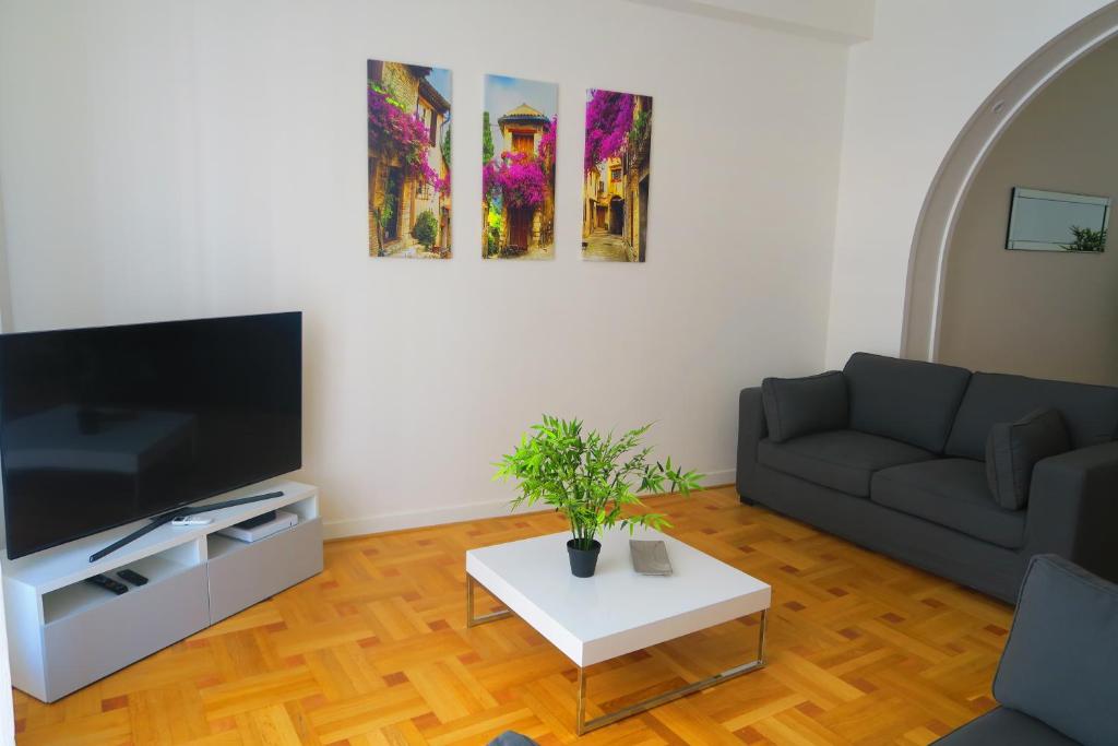 un salon avec un canapé et une télévision dans l'établissement Carré d’Or Appt 4 Pièces moderne et spacieux, à Nice