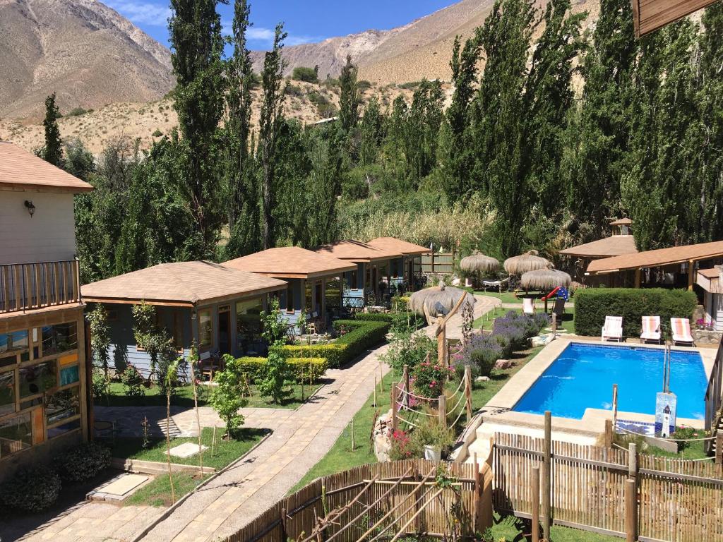 un complejo con piscina y montañas de fondo en Hotel Faro del Valle, en Pisco Elqui