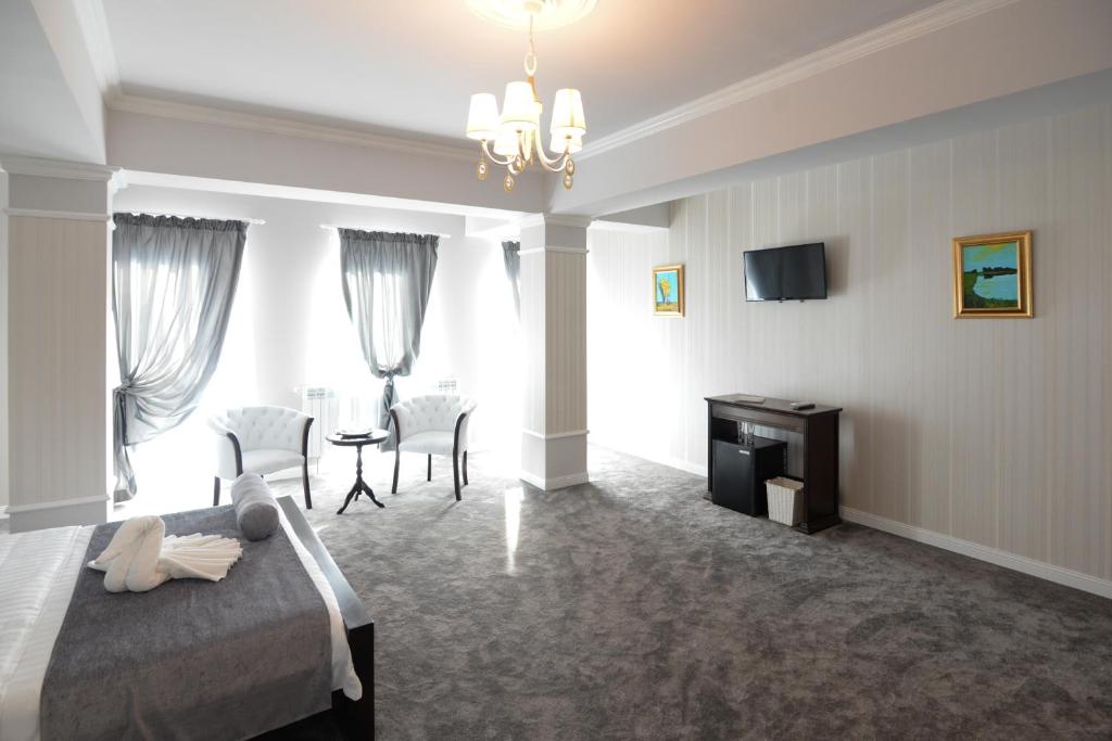 a bedroom with a bed and a table and chairs at The Classic in Buzău