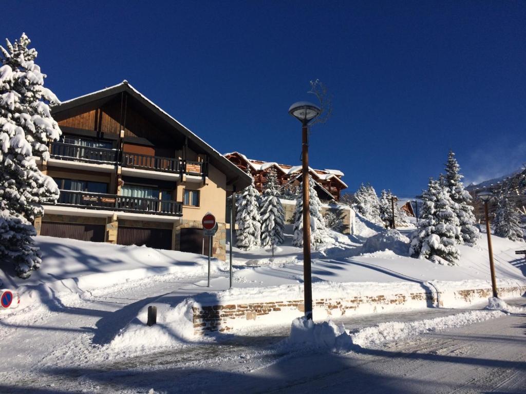 a building with a light pole in the snow at Chalet Amandine in L'Alpe-d'Huez