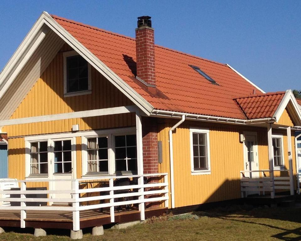 a yellow house with an orange roof at Schwedenhaus-Seeblick-Useriner-See in Userin