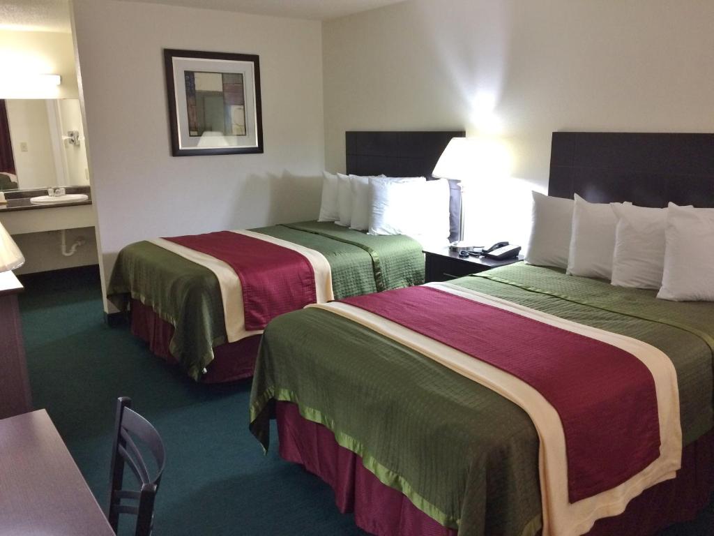 a hotel room with two beds and a table at Travel Inn & Suites in Atlanta
