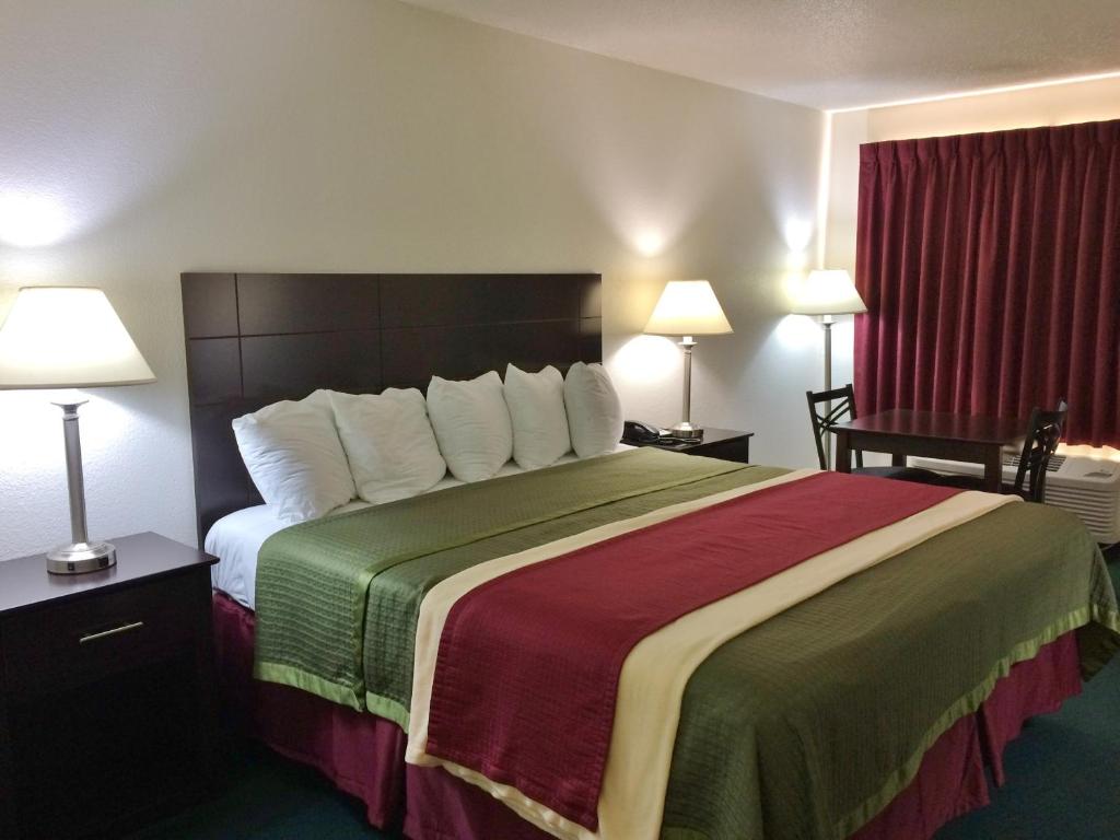 a hotel room with a large bed and two lamps at Travel Inn & Suites in Atlanta