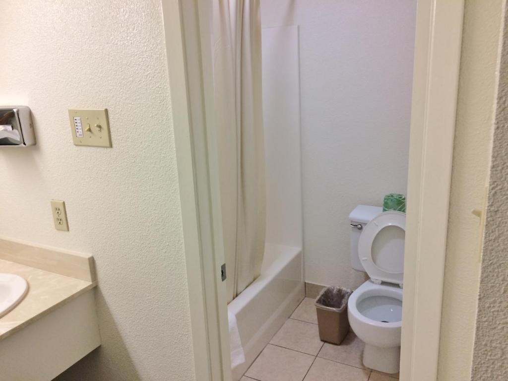 a bathroom with a toilet and a sink at Travel Inn & Suites in Atlanta