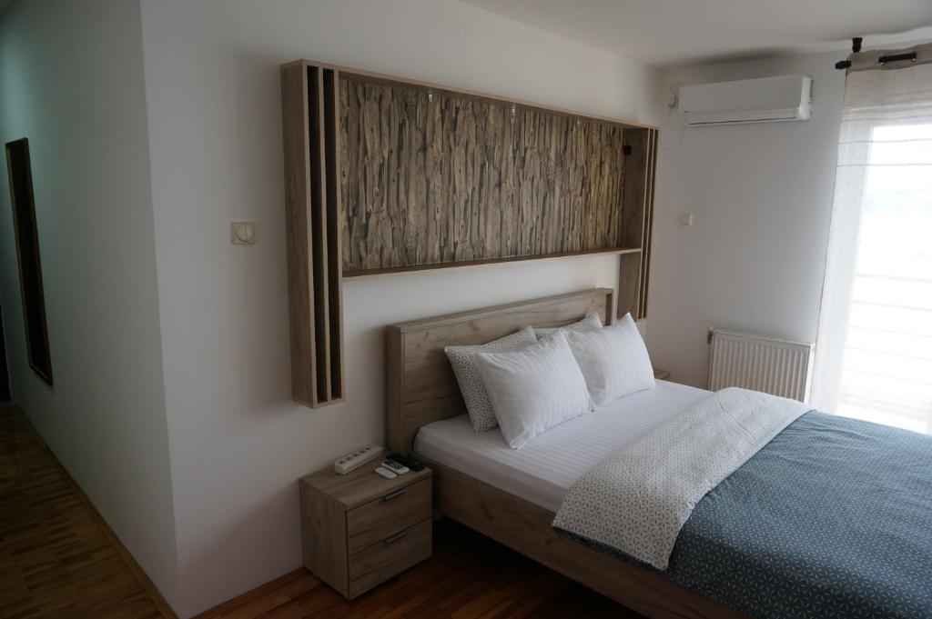 a bedroom with a bed with a picture on the wall at Nice apartment in Niš