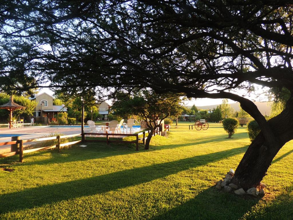 諾諾的住宿－Refugio de Luna Cabañas & Suites，公园里有树,栅栏和草地