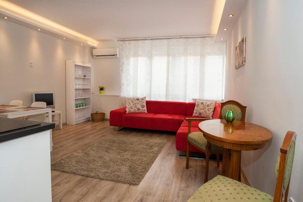 ブダペストにあるIlona 2 bedrooms apartment in the centerのリビングルーム(赤いソファ、テーブル付)