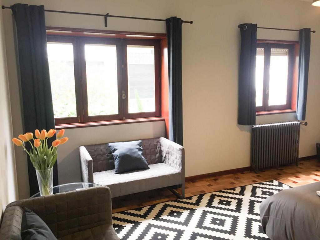 a living room with a couch and two windows at AC House in Porto