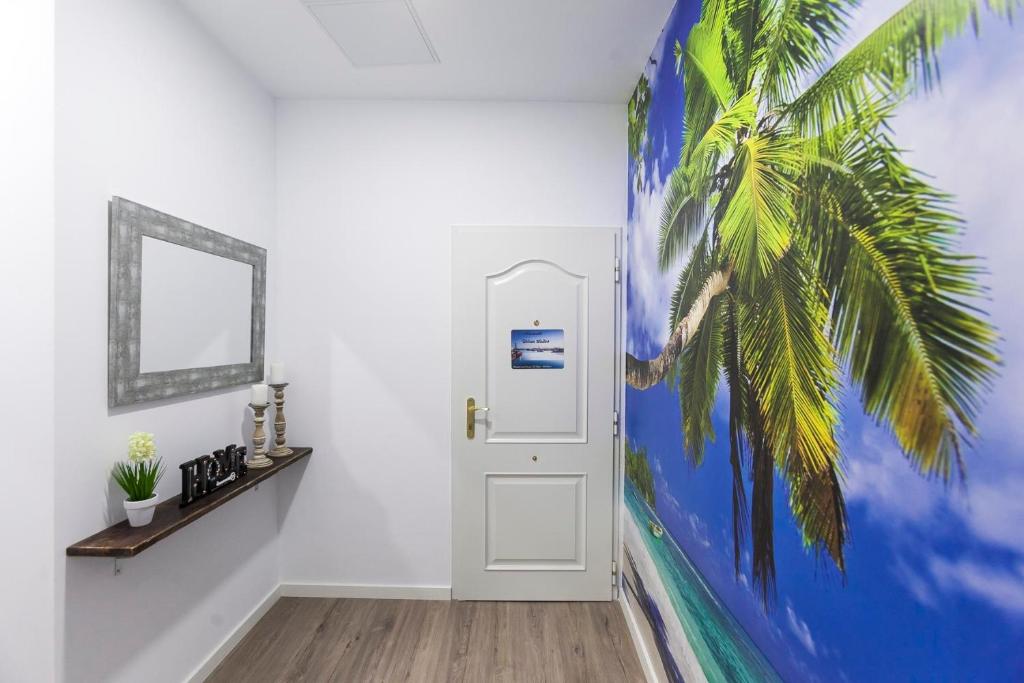 a hallway with a palm tree mural next to a door at Adorable urban suites in Las Palmas de Gran Canaria