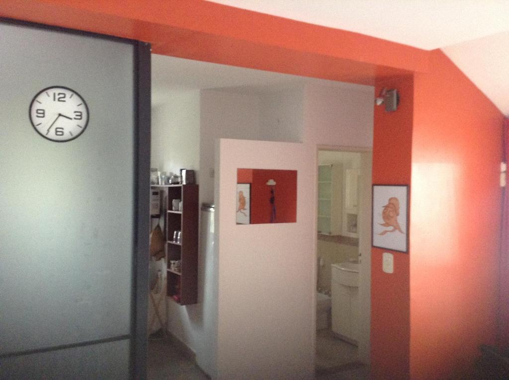 una habitación con un reloj en la pared y un pasillo en La Casa Roja Arroyito Rio en Rosario