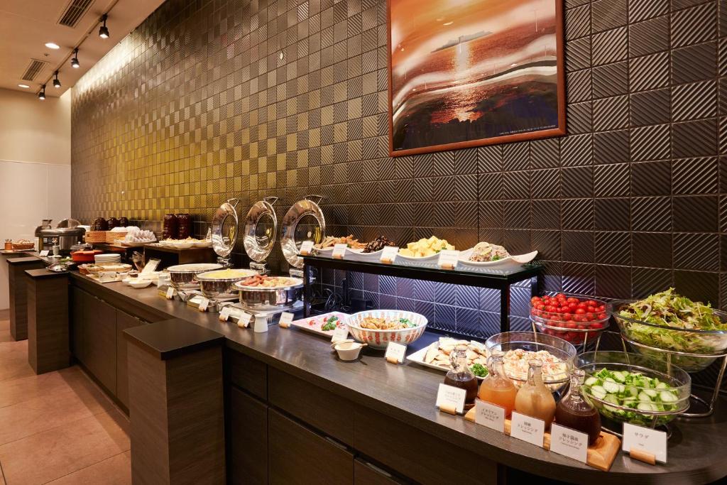 
a long counter with many different types of food on it at S Peria Hotel Nagasaki in Nagasaki
