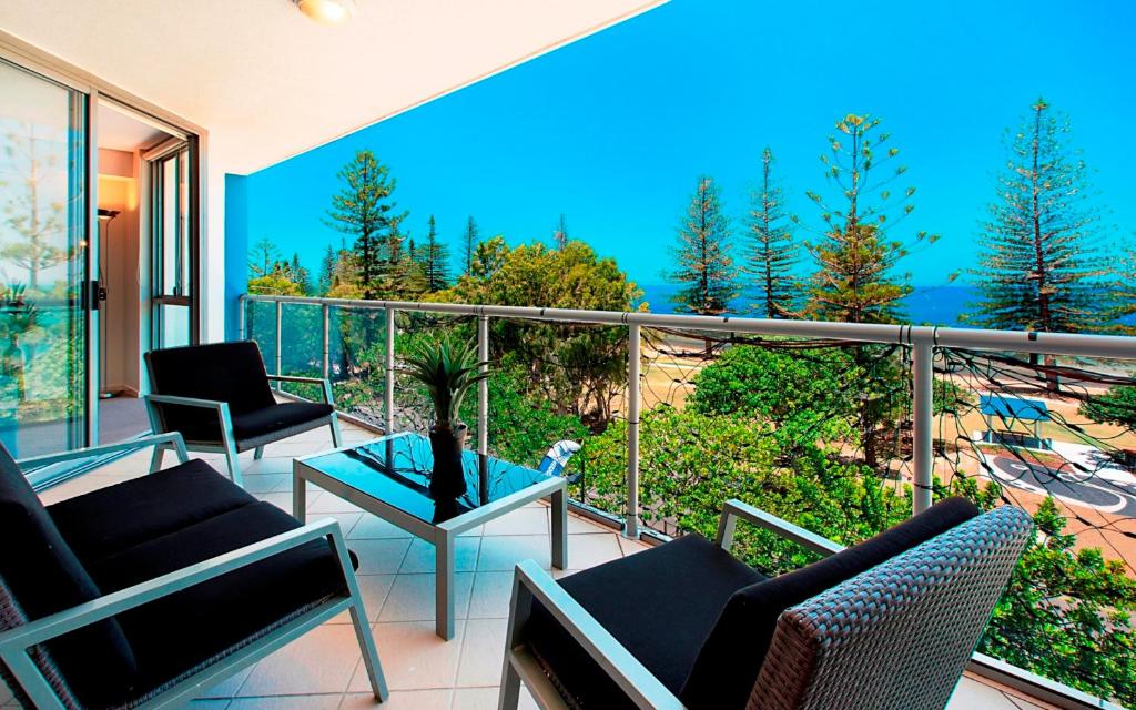 a balcony with chairs and a table with a view at Scarborough Beach Resort Brisbane in Scarborough