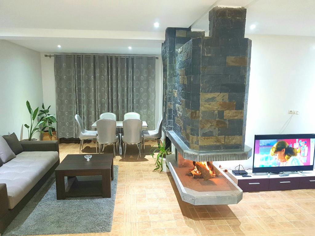 ein Wohnzimmer mit einem Sofa und einem Kamin in der Unterkunft Chalet Asmoun in Imouzzer du Kandar