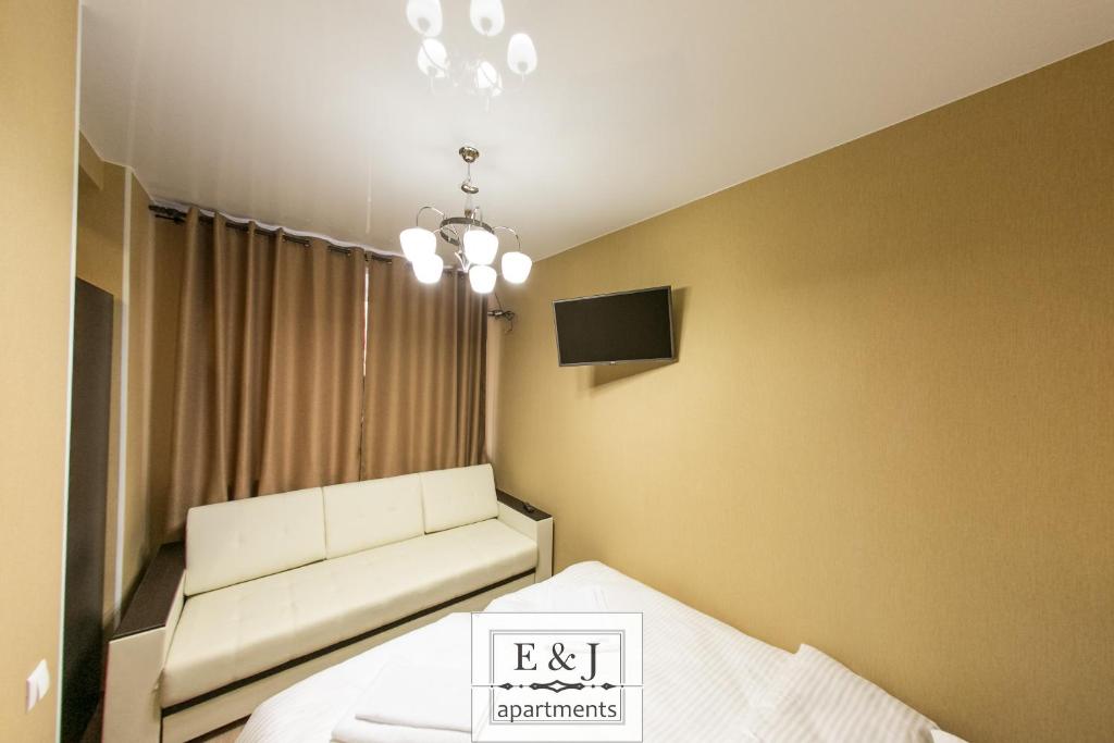 a hotel room with a bed and a lamp on the wall at Apartment E&J in Krasnoyarsk