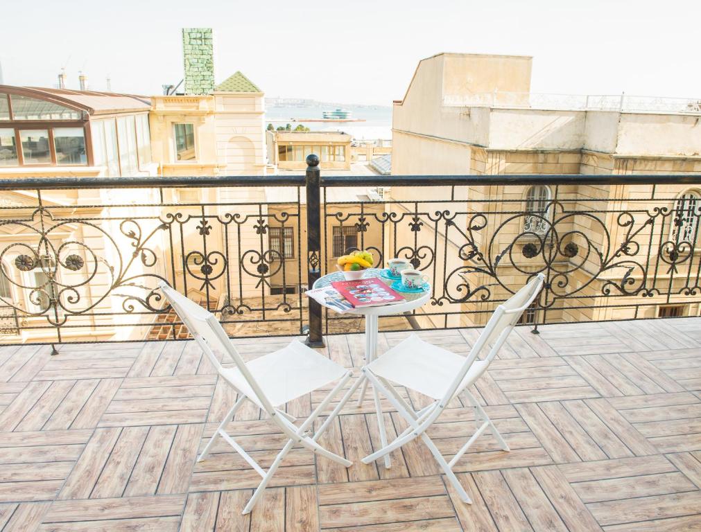 een tafel en 2 stoelen op een balkon bij Two Seasons Boutique Hotel Baku in Baku