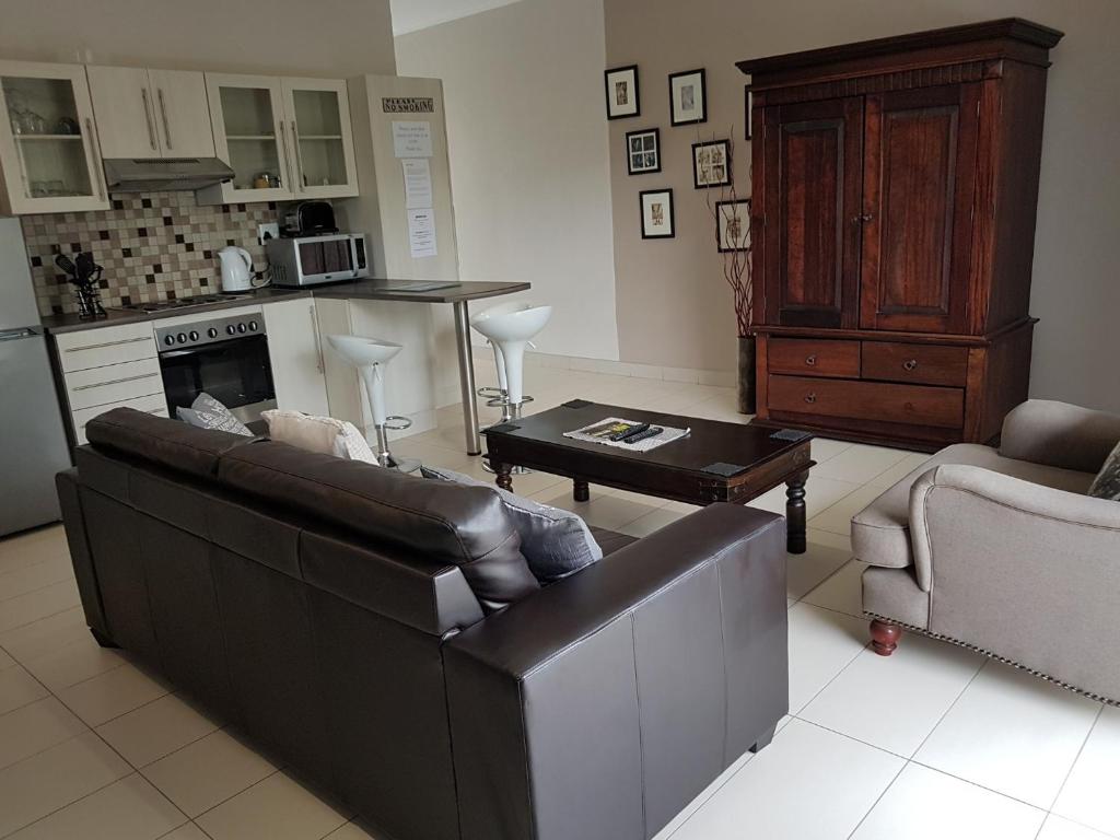- un salon avec un canapé et une table dans l'établissement Rieks van der Walt Self-Catering Apartment, à Windhoek