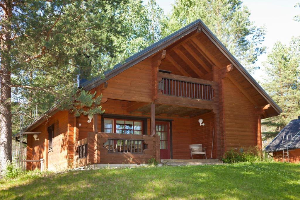 a log cabin in the woods with a large window at Holiday Club Hannunkivi Cottages in Kivijärvi