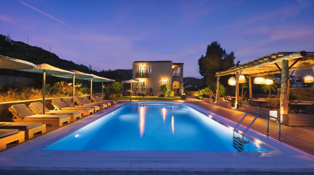a swimming pool with lounge chairs and a house at Anemoessa Luxury Villas in Fanari