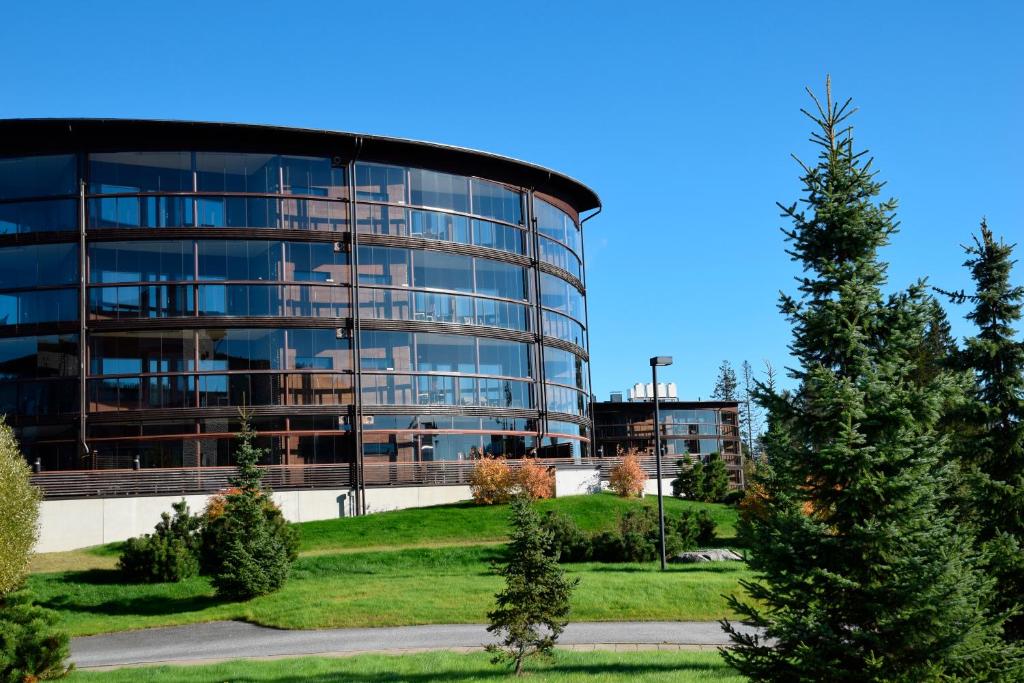 a large glass building with a tree in front of it at Holiday Club Tahko Spa Apartments in Tahkovuori