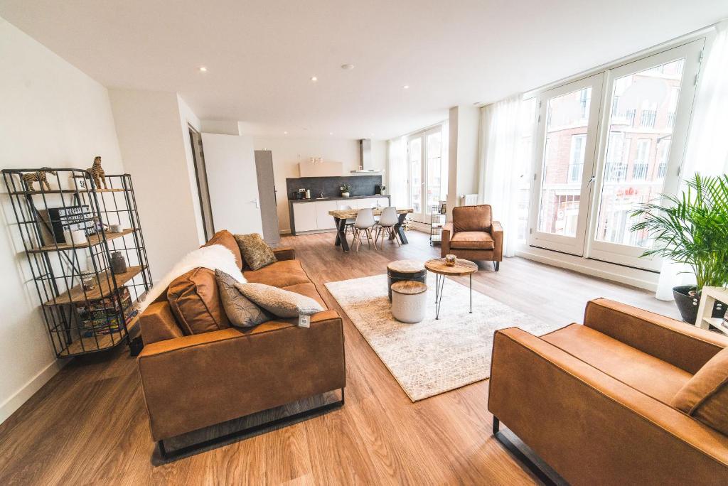 a living room with two couches and a table at Stadslogies in Leeuwarden in Leeuwarden