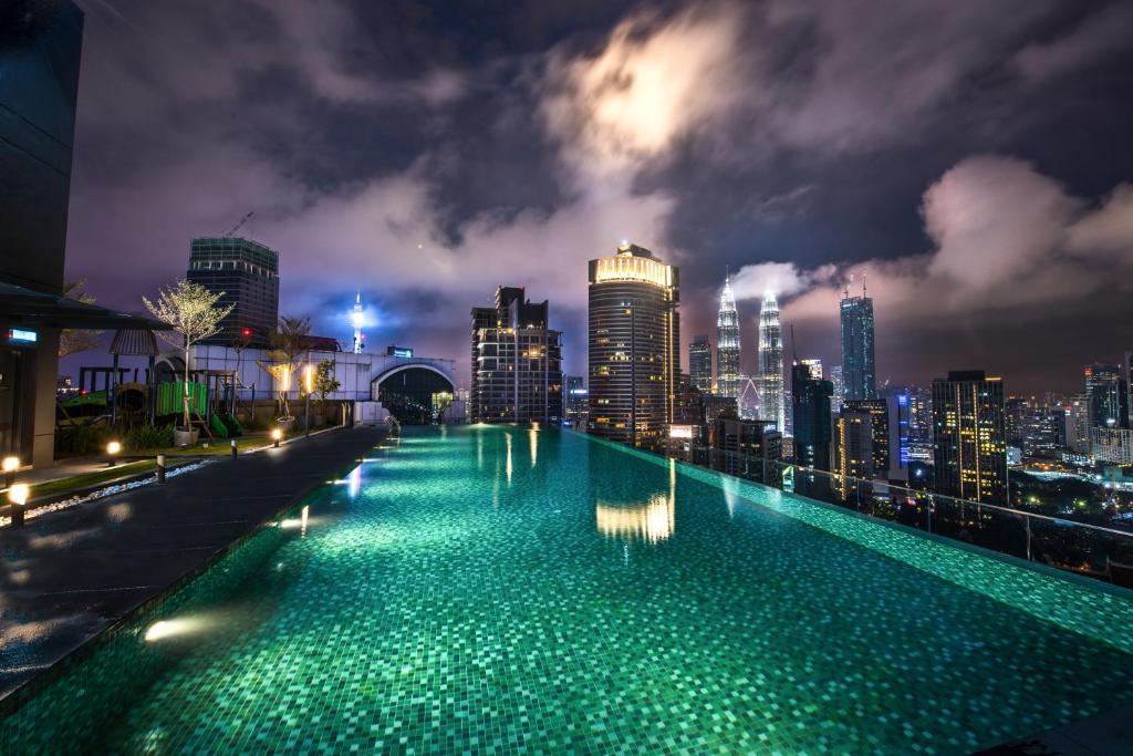 a swimming pool with a city skyline at night at Dorsett Residences Bukit Bintang @Dorsett Kuala Lumpur in Kuala Lumpur