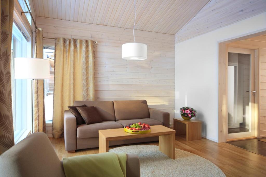 a living room with a couch and a table at Holiday Club Himos Apartments in Jämsä