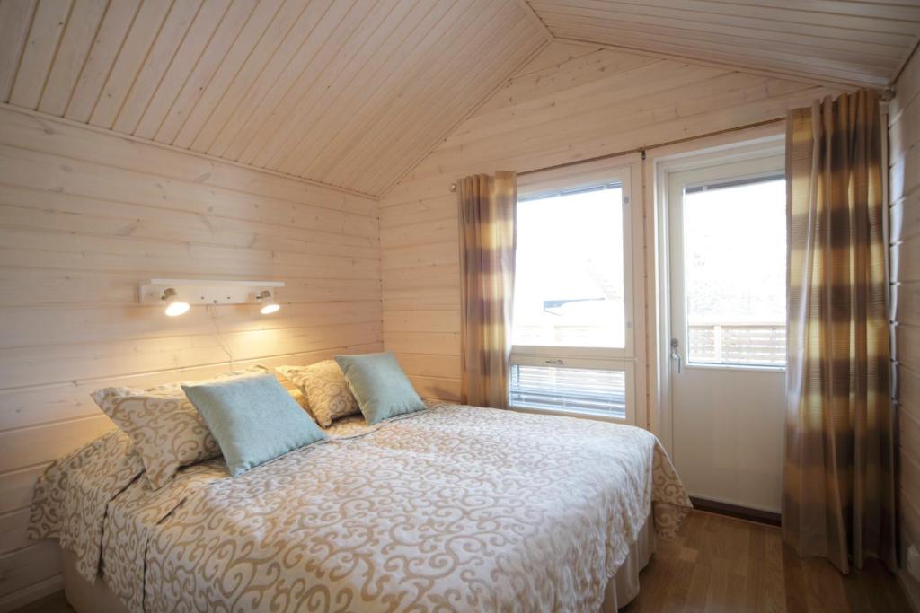 a bedroom with a bed with two pillows and a window at Holiday Club Himos Apartments in Jämsä