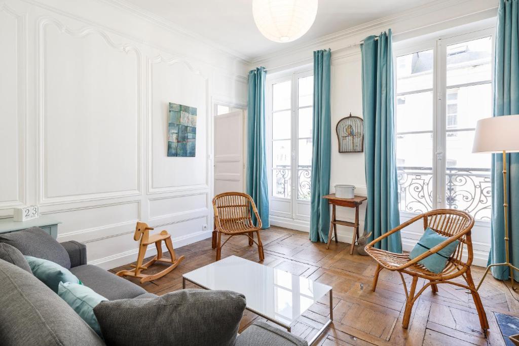 een woonkamer met een bank en een tafel bij Ty Paradis by Cocoonr in Rennes