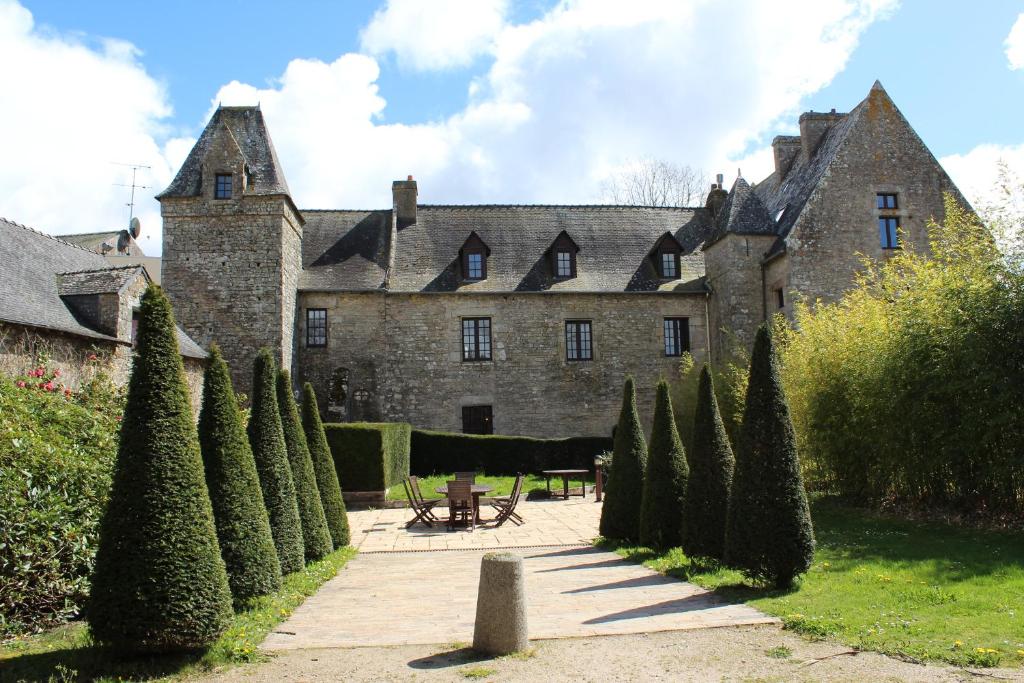 un viejo castillo con un montón de árboles delante de él en La Maison OBONO en Le Bono