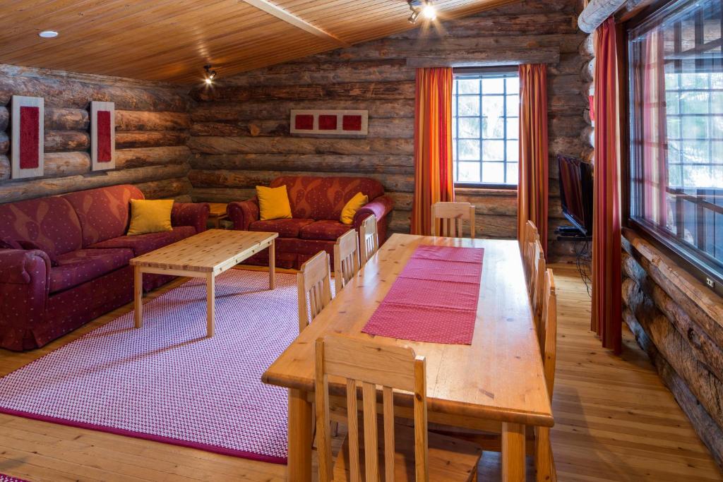 a living room with a table and a couch at Holiday Club Ruka Cottages in Oivanki