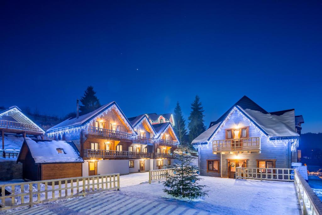 a large house in the snow at night at Family Hotel Cascad in Bukovel