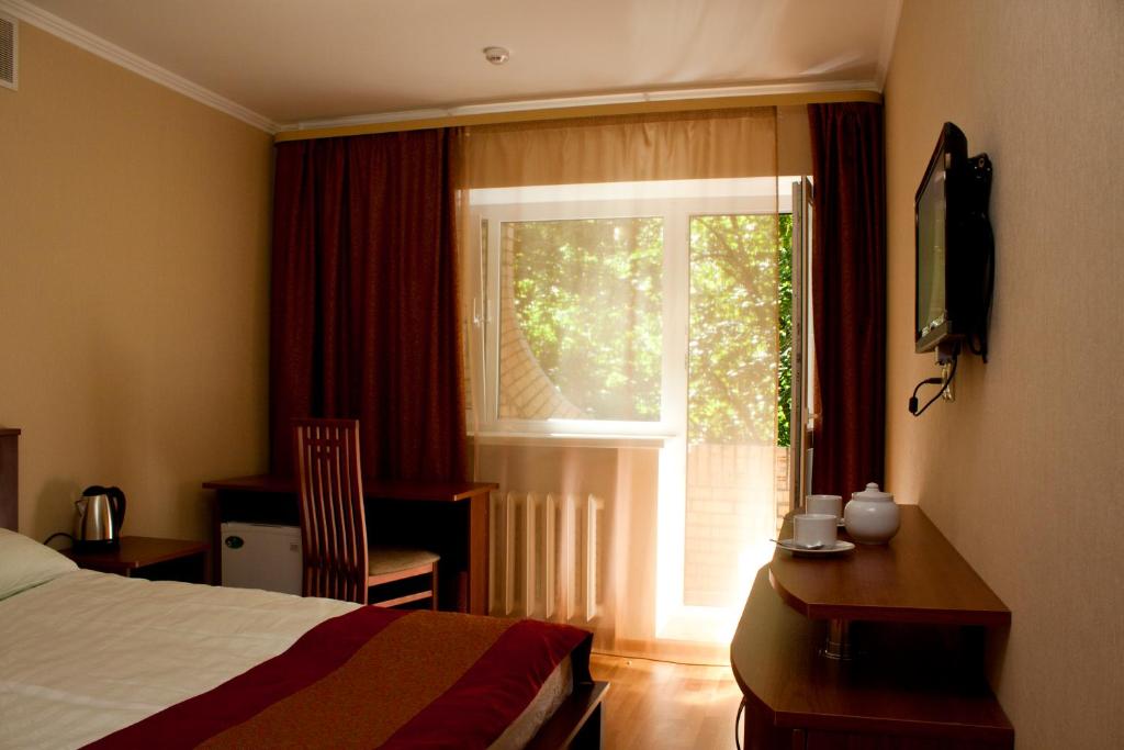 モスクワにあるPark Hotel Velesのベッドルーム1室(ベッド1台、デスク、窓付)
