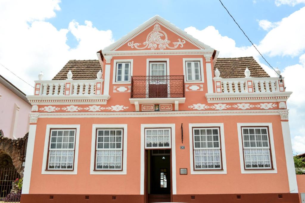 a pink building with a balcony on top of it at Pousada Solar da Lapa in Lapa