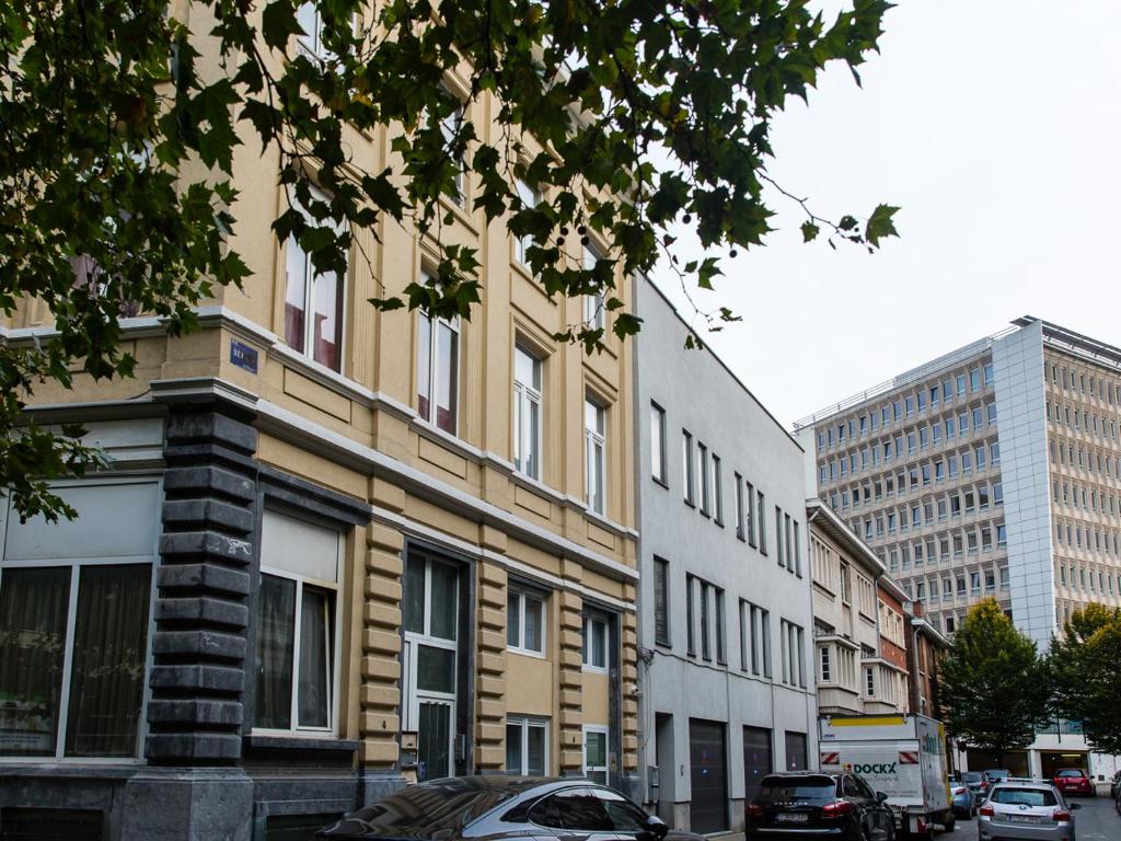 een rij gebouwen in een stadsstraat met auto's bij Urban Suites Brussels Schuman in Brussel