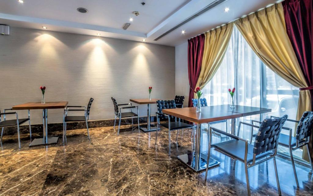 a restaurant with tables and chairs and a window at Executive Suites Abu Dhabi in Abu Dhabi