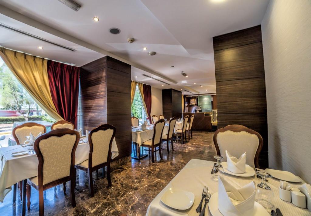 a dining room with white tables and chairs at Executive Suites Abu Dhabi in Abu Dhabi