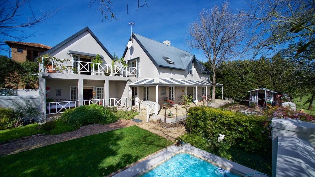 a house with a swimming pool in front of it at Baruch Guest House in Stellenbosch