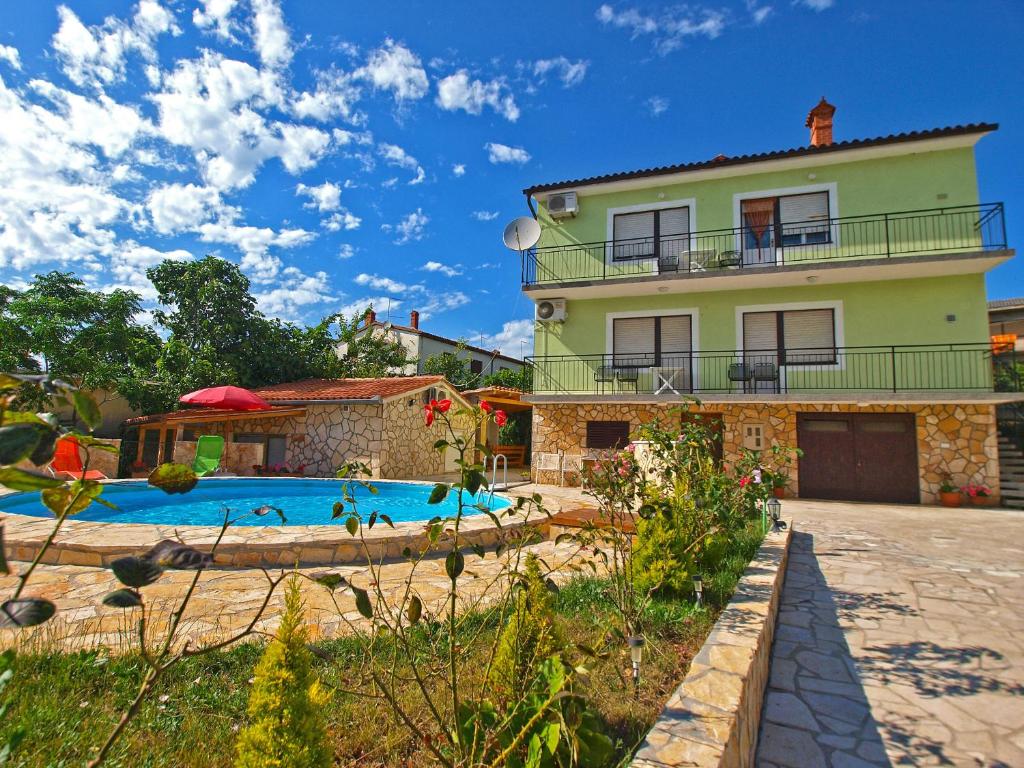 a house with a swimming pool in front of it at Apartments Ivanka 1056 in Pula